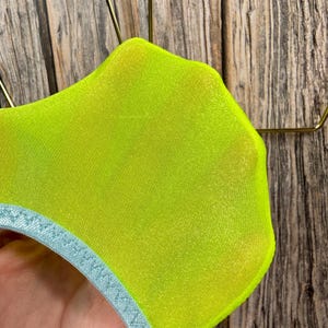 May include: A pair of neon yellow sheer socks with a light blue trim around the top.