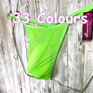 May include: A neon green sheer mesh thong featuring thin side straps and a black tag with the text 33 Colours and iovanadesign. The garment is displayed on a gold-toned wire hanger, showcasing a lightweight, semi-transparent fabric construction.