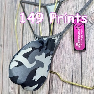 May include: A thong with a camouflage pattern in shades of gray, black, and white. The garment is suspended on a gold-colored hanger. The text "149 Prints" is visible in the image, along with a tag that reads "Jovana Design".