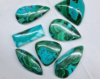 May include: A collection of seven polished gemstones featuring vibrant swirls of deep forest green and bright turquoise blue. These cabochons display intricate banded patterns and organic shapes, including teardrop, rectangular, and triangular forms.