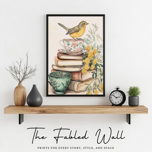 Pu&ograve; includere: Una stampa ad acquerello incorniciata con un uccello giallo appollaiato su una tazza da t&egrave;, impilata su libri. La tazza e il piattino hanno un motivo floreale. Una tazza da t&egrave; verde &egrave; in basso. La stampa &egrave; su una mensola di legno con vasi e un orologio.