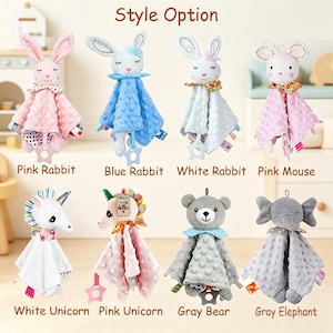 Puede incluir: Una colecci&oacute;n de ocho mantitas de apego de peluche con cabezas de animales, incluyendo conejos, un rat&oacute;n, unicornios, un oso y un elefante. Cada juguete tiene un cuerpo de tela texturizada con relieve, un cuello estampado y un mordedor de estrella.