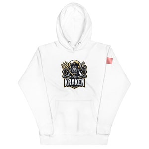 May include: White hooded sweatshirt with a graphic of a kraken holding a trident and the word "Kraken" in gold lettering. The sweatshirt has a small American flag patch on the sleeve.