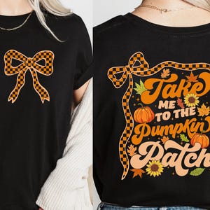 以下が含まれることがあります： オレンジと黒のチェック柄のリボンが描かれた黒いTシャツ。Tシャツの背面には、カボチャ、葉、ヒマワリとともに「Take Me To The Pumpkin Patch」の文字がプリントされています。