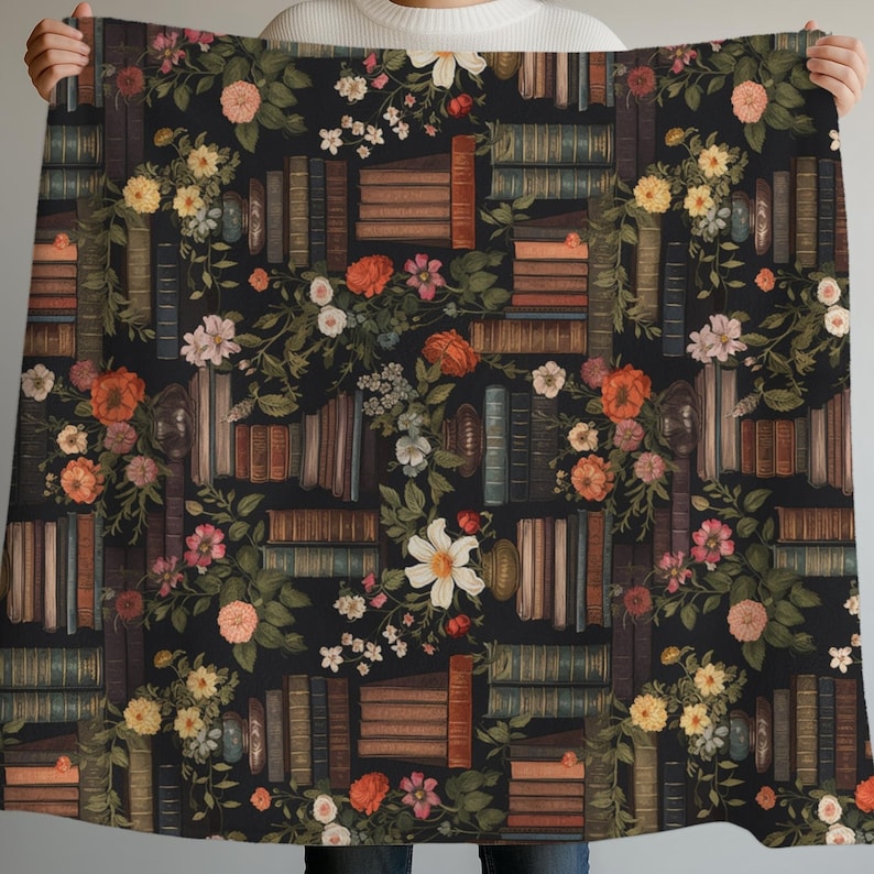 Peut inclure: Une couverture noire avec un motif r&eacute;p&eacute;t&eacute; de vieux livres et de motifs floraux. Le motif comprend des piles de livres de diff&eacute;rentes tailles et couleurs, entrecoup&eacute;es de roses, de marguerites et d'autres fleurs dans des tons d'orange, de rose et de blanc.