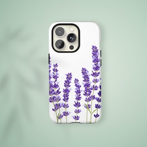 May include: A white smartphone case featuring a botanical illustration of purple lavender sprigs with green stems. The design covers the lower portion of the case, showcasing multiple stalks of lavender flowers against a clean white background.