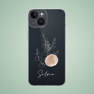 May include: A black phone case featuring a white line drawing of a plant and a pink watercolour circle. The name "Silvia" is written in white script below the circle.