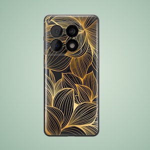 May include: Black phone case with a gold floral design. The phone case has a camera bump with three lenses.