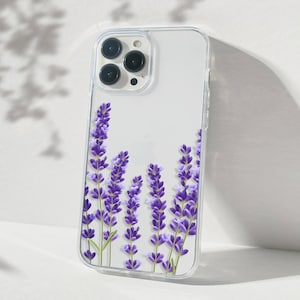 May include: A clear phone case with a lavender floral design. The case has a raised camera bump and a clear back.
