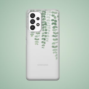 May include: A clear phone case with a design of green leaves hanging down. The case has the word "SAMSUNG" printed on the back.