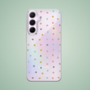 Può includere: Una custodia per telefono trasparente con un motivo di impronte di zampe colorate. La custodia è progettata per un telefono Samsung e ha un rialzo per la fotocamera rialzato.