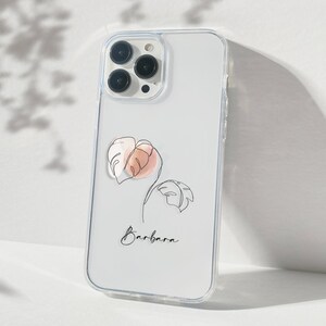 May include: A clear phone case with a white background and a line drawing of a tropical leaf in pink and orange. The name "Barbara" is written in black below the leaf.