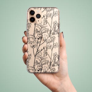 May include: A clear phone case with a black floral design. The case is designed for an iPhone with a triple lens camera.
