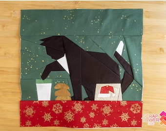 May include: A black and white cat with a red Santa hat is sitting on a green background with gold stars. The cat is looking to the left. The background is a green fabric with gold stars. The bottom of the image is a red fabric with gold snowflakes. The text "Scrap Tower Studio" is in the bottom right corner of the image.