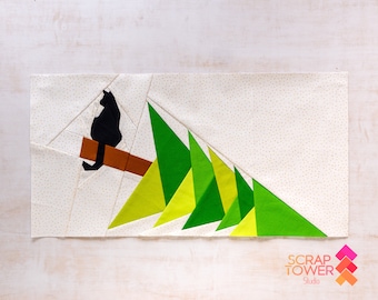 May include: A black cat sits on a brown branch, looking at a row of green and yellow triangles, resembling a stylized Christmas tree. The background is a white fabric with small gold dots.