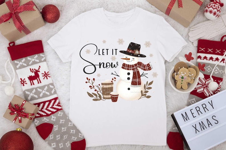 May include: White t-shirt with a snowman graphic and the text "Let it snow". The snowman is wearing a red and black plaid scarf and a black hat.