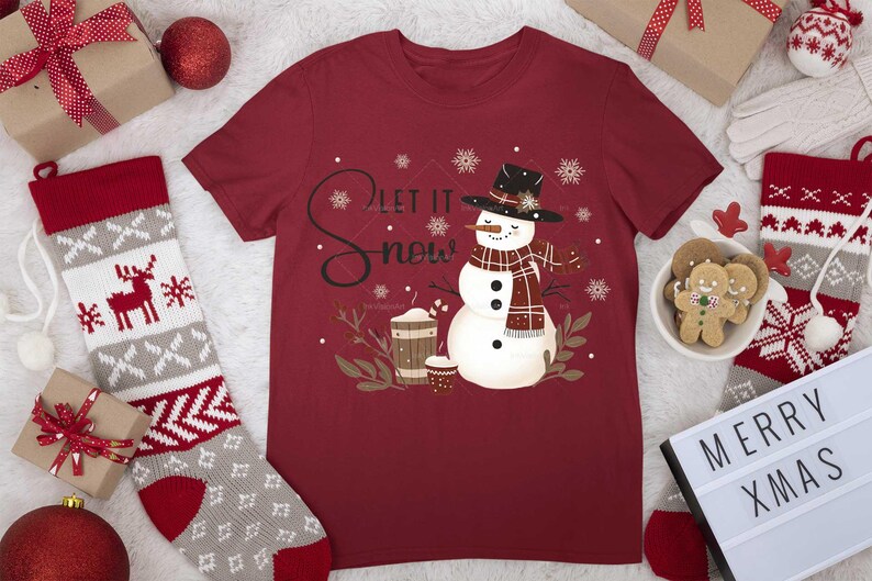 May include: Red t-shirt with a snowman graphic and the text "Let it snow". The snowman is wearing a red and black plaid scarf and a black hat.