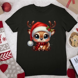 Op de afbeelding: Een zwart T-shirt met een cartoon afbeelding van een rendier dat een kerstmanmuts en een rood-zwarte geruite sjaal draagt. Het rendier heeft grote, blauwe ogen en een vriendelijke uitdrukking.