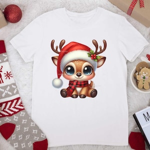 Op de afbeelding: Wit T-shirt met een cartoon afbeelding van een rendier dat een rode kerstmanmuts en een rood-zwarte sjaal draagt. Het rendier heeft grote blauwe ogen en een bruine neus.