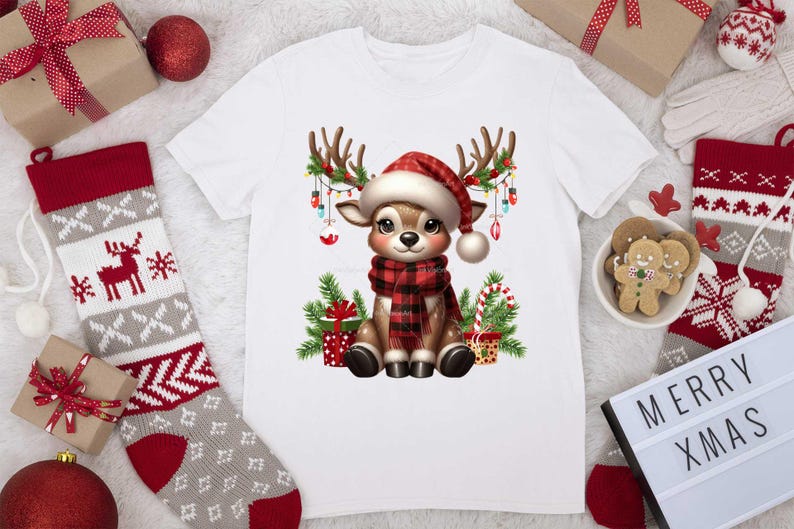Pode incluir: Camiseta branca com uma rena de desenho animado usando um chap&eacute;u de Papai Noel e uma echarpe xadrez vermelha e preta. A rena est&aacute; cercada por luzes de Natal, presentes e bengalas de doces.