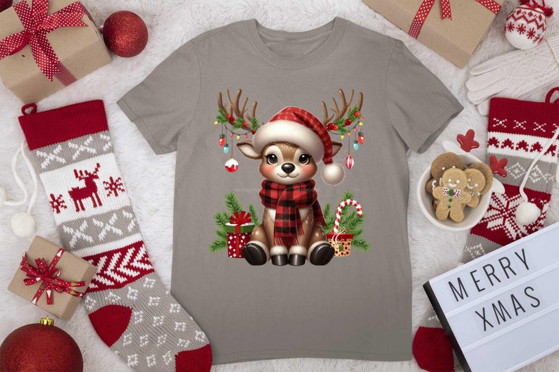 Pode incluir: Uma camiseta cinza com uma rena de desenho animado usando um chap&eacute;u de Papai Noel vermelho e branco e uma echarpe xadrez vermelha e preta. A rena est&aacute; cercada por luzes de Natal, presentes e bengalas de doces.