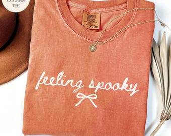 Camiseta de Halloween con sensación espeluznante para mujer, linda camiseta con gráfico de lazo cursivo, camiseta retro coqueta de otoño, camiseta estética de temporada espeluznante con colores cómodos.