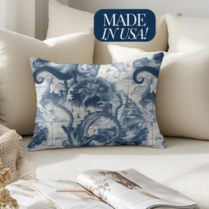 May include: A blue and white throw pillow with a nautical map design featuring an octopus and a ship. The pillow has the text "MADE IN USA!" on it.