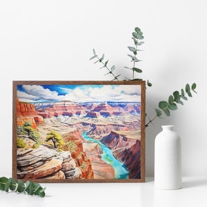 Op de afbeelding: Een ingelijst aquarel schilderij van de Grand Canyon, met een kronkelende rivier en gelaagde rotsformaties in tinten rood, bruin en blauw.