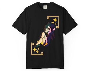 May include: Black t-shirt featuring a cartoon character with green hair, an X over the eyes, and a purple coat. The design is framed by gold borders with stars. The shirt is a casual wear item.