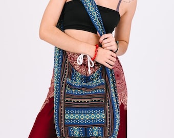 May include: A blue and brown patterned shoulder bag with a long strap. The bag has a front pocket and a drawstring closure. The strap and the bag feature geometric designs. The bag is worn over the shoulder.