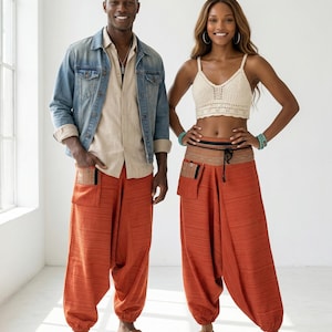 May include: A man and woman are modeling clothing. The man wears a denim jacket, tan shirt, and orange pants. The woman wears a crochet top and orange pants. The pants have pockets. The text "Home 648 Studio" and height measurements are visible.
