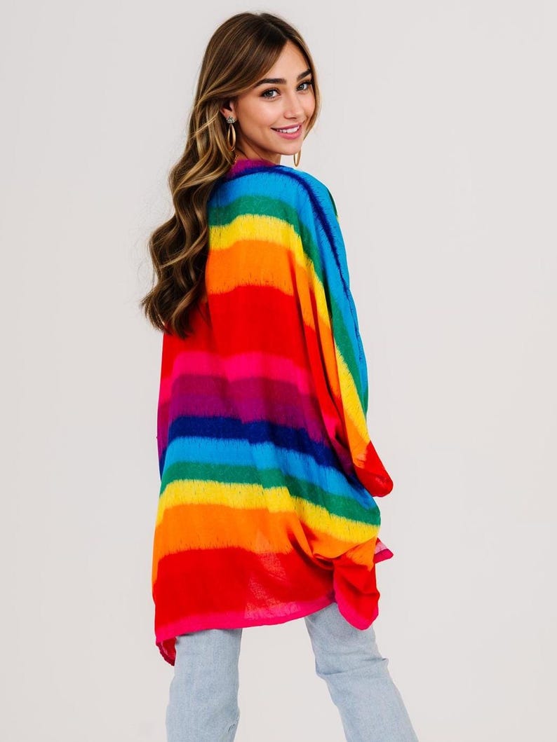 Pu&ograve; includere: Un top in stile kimono a righe arcobaleno vibrante. L'indumento colorato presenta bande orizzontali di rosso, arancione, giallo, verde, blu e viola. Il tessuto leggero drappeggia liberamente, creando una silhouette fluida. Il top &egrave; un capo audace.