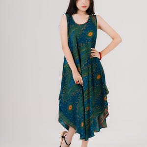 Maxi sleeveless dress with bold rainbow print, modeled by woman in black sandals. Great choice for beach days or casual outings.