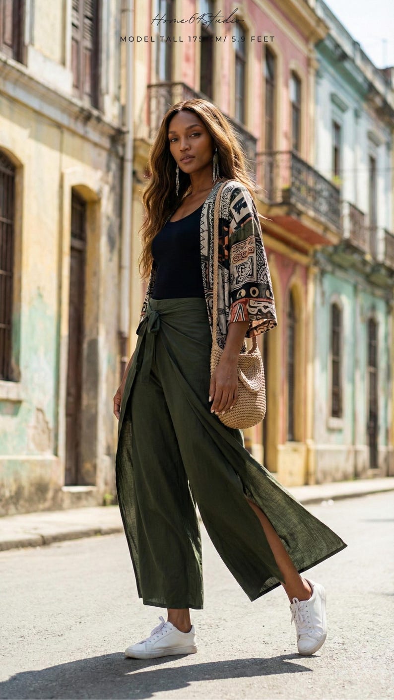 Travel in style with our Plain Army Green Palazzo Pants! ✈️ These highly breathable boho fit trousers are the perfect holiday staple for exploring colorful city streets. The comfortable wrap style with bold side slits and a tie-waist offers fantastic mobility. 🚶‍♀️ Flawlessly styled with white sneakers, a black tank, and a vibrant printed kimono for an ultimate tourist-chic look. Stay cool in the summer heat while looking totally effortlessly put-together in these flowy wide-leg pants. 🌍