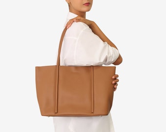 May include: A brown leather tote bag with a structured design and top handles. The bag is large enough to carry everyday essentials.