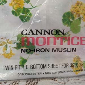 Puede incluir: Una sábana bajera ajustable blanca para cama individual en envase de plástico con estampado floral amarillo y verde. La etiqueta dice CANNON MONTICE NO-IRON MUSLIN TWIN FITTED BOTTOM SHEET PARA 99 X 193 CM, 50% POLIÉSTER, 50% ALGODÓN.