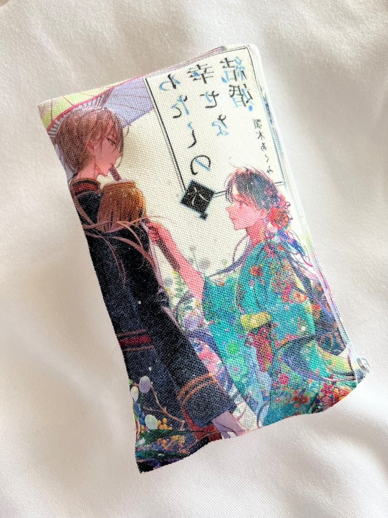 May include: A white canvas pouch with a colorful anime illustration of two people. The text on the pouch reads "桜  咲く  時の  桜  咲く  時  -  藤木  ゆたか - "