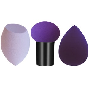 Könnte beinhalten: Drei violette Make-up-Schwämme, einer ist rund und auf einem schwarzen Ständer, einer ist tropfenförmig und einer ist oval.