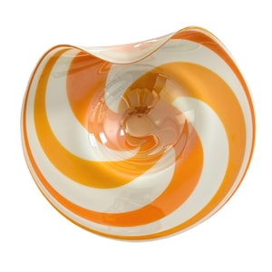 May include: A decorative glass bowl with a swirl design. The bowl features alternating orange and white stripes that spiral inward. The rim of the bowl has a slight wave. The bowl is transparent, allowing light to pass through.