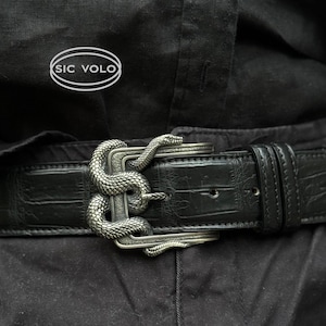 May include: A black leather belt with a silver snake buckle. The buckle is detailed with a snake design and the words "SIC VOLO" are visible on the belt.