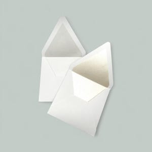 Op de afbeelding: Twee witte enveloppen met openstaande kleppen, die een lichtgekleurde binnenkant onthullen. De enveloppen zijn geplaatst tegen een zachte, gedempte achtergrond. De enveloppen zijn waarschijnlijk voor uitnodigingen of briefpapier.