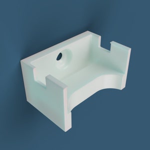 May include: A white plastic wall mount with a rounded front and a hole in the back for mounting.