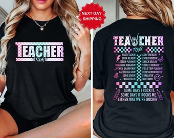 May include: Black t-shirt with a pink, blue, and green checkered design and the text "Teacher Tour" in white. The back of the shirt has the text "Teacher Tour" in white with a list of tasks teachers do, including "Multi Tasking", "Conferencing", "Book Reading", "Paper Grading", "Lesson Planning", "Snack Dealing", "Behavior Managing", "Coffee Drinking", "Pencil Sharpening", "Field Trip Planning", "Cafeteria Going", "Recess Monitoring", "Song Singing", "Evaluating", "Negotiating", "Nurturing". The text "Some days I rock it. Some days it rocks me. Either way we're rockin'" is below the list.