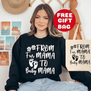 May include: Black sweatshirt with white text that reads "From Fur Mama to Baby Mama" with paw prints and baby footprints. A white tote bag with the same text in black.