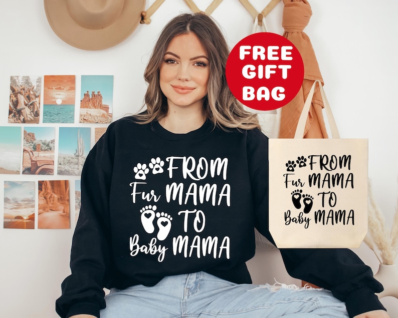 May include: Black sweatshirt with white text that reads "From Fur Mama to Baby Mama" with paw prints and baby footprints. A white tote bag with the same text in black.
