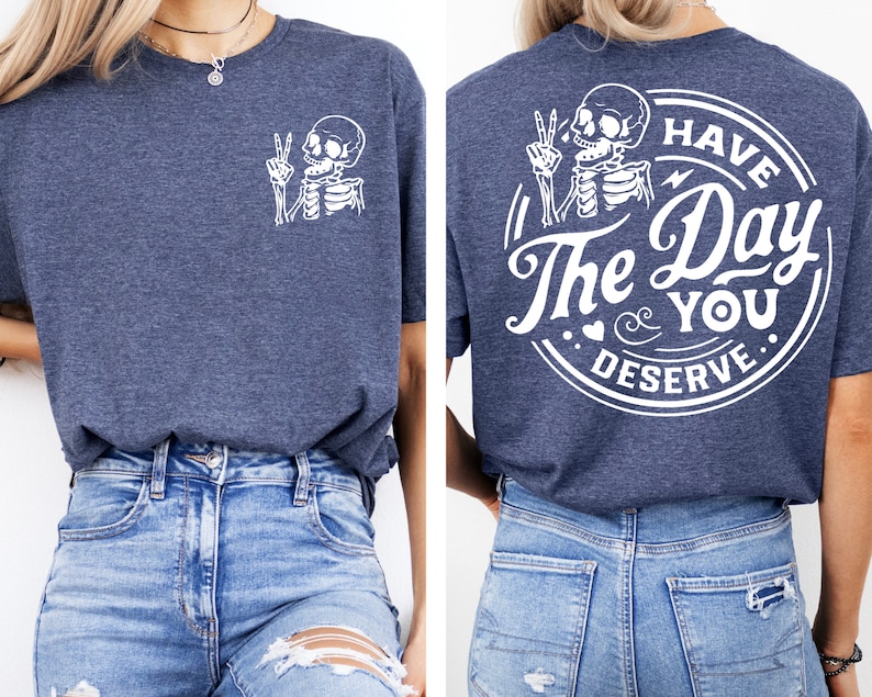 May include: A navy blue t-shirt with a white skeleton graphic on the front and a white circle graphic on the back that says "Have The Day You Deserve".
