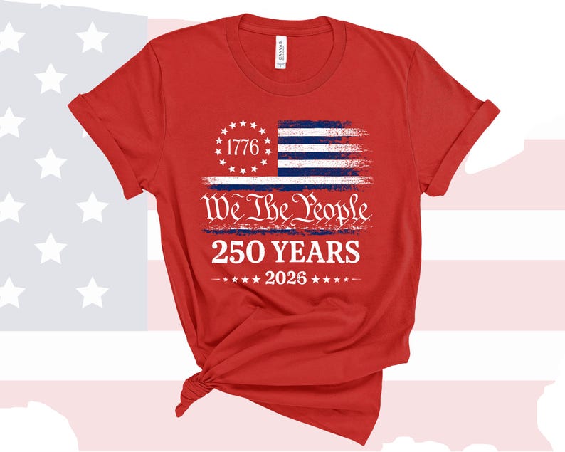 May include: A red short-sleeved t-shirt featuring a graphic of a distressed American flag with a circle of stars and the number 1776. Below this, the text reads We The People, 250 YEARS, and 2026, accented by a row of small white stars.