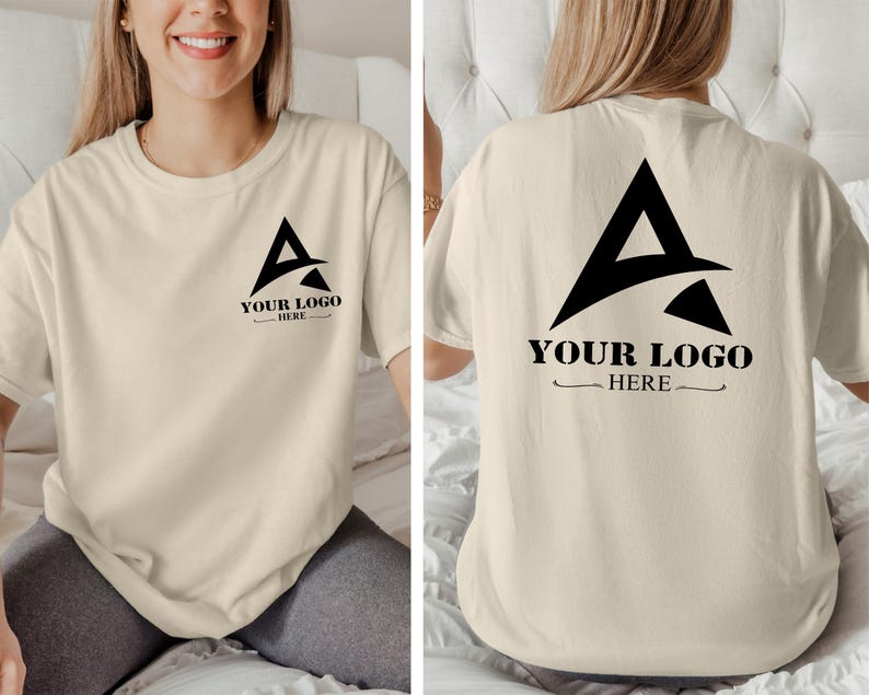 May include: A beige t-shirt with a black graphic of a stylized letter A with the text "YOUR LOGO HERE" on the front and back.