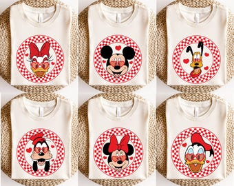 May include: Six white t-shirts with red and white checkered circles featuring different Disney characters wearing heart-shaped sunglasses. The characters include Mickey Mouse, Minnie Mouse, Donald Duck, Goofy, and Pluto.