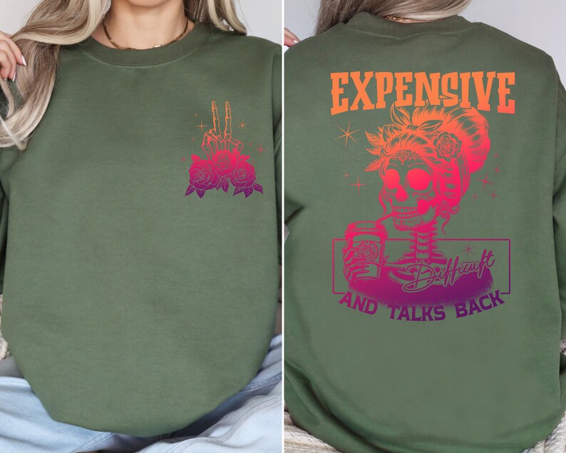 May include: Green sweatshirt with a pink and purple graphic of a skull holding a coffee cup and the text "Expensive and Talks Back". The front of the sweatshirt has a pink and purple graphic of a hand with roses.